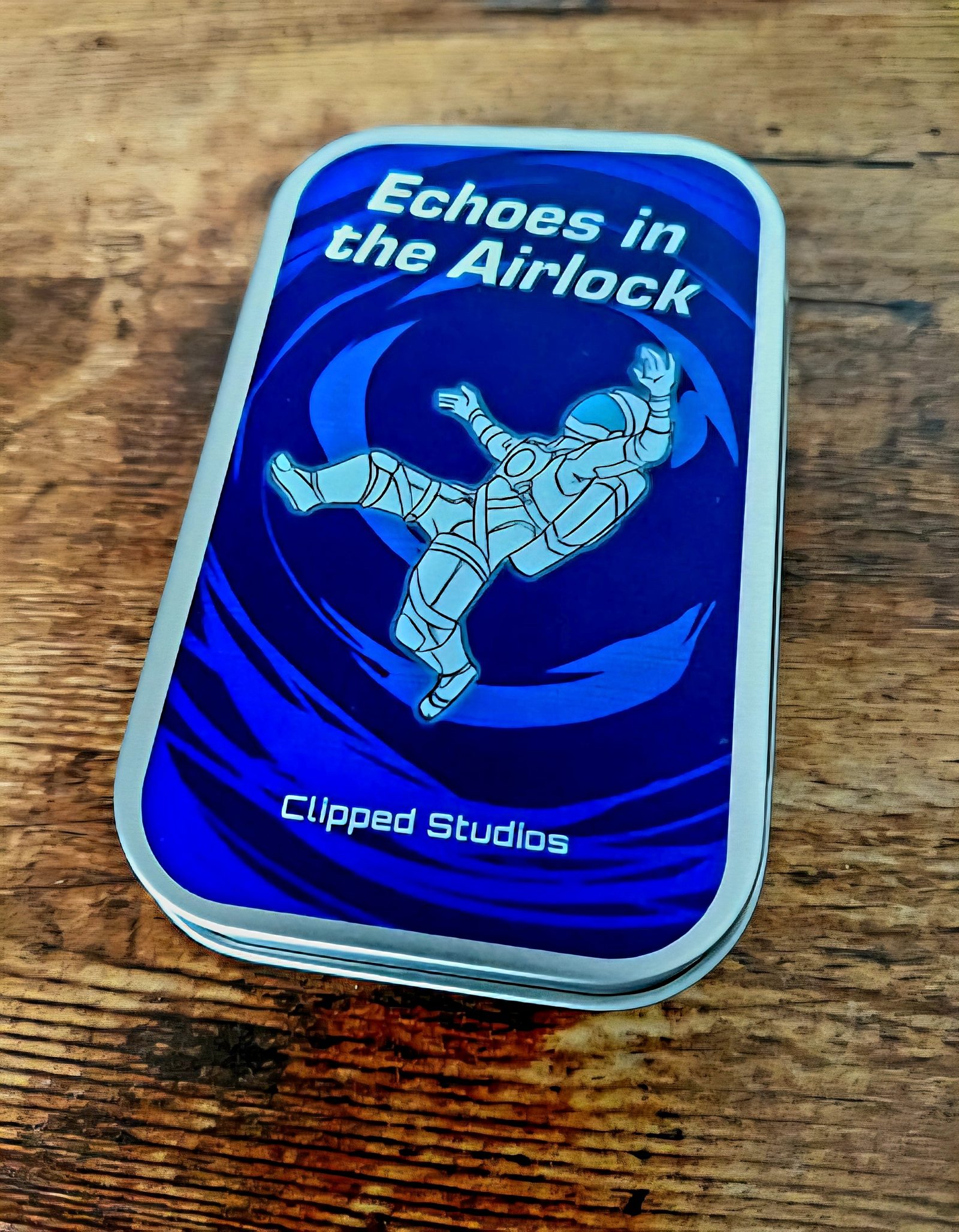 Echoes in the Airlock game tin on a wooden table